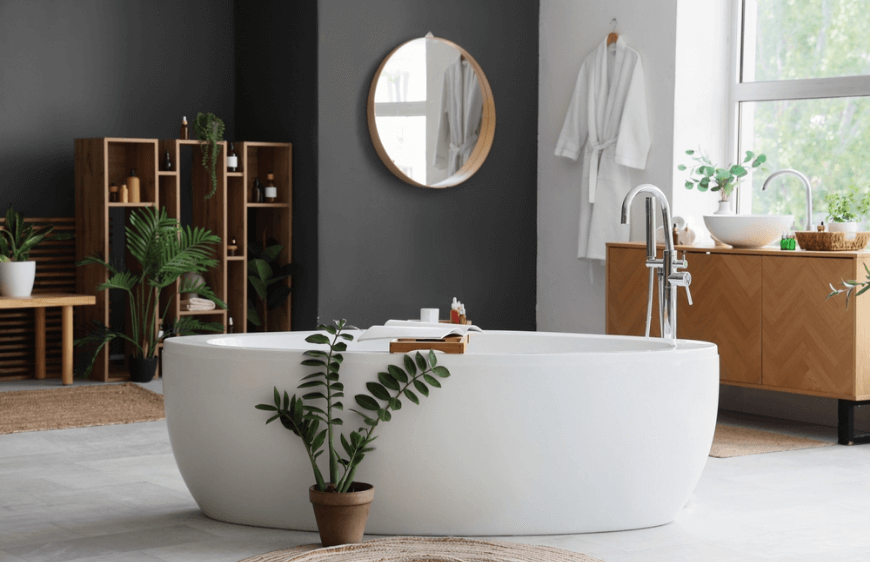 beyaz kuvetli modern banyo,kuvetin onundaki cicek,ciceklerle dolu banyo, banyoda bulunan ahsap raflar,modern minimal banyo tasarimi,banyonun ortasindaki beyaz kuvet